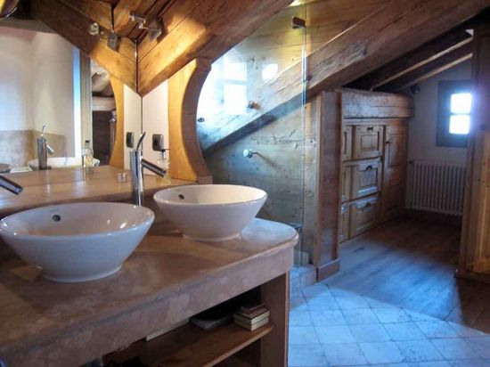 A bathroom with exposed roof beams.